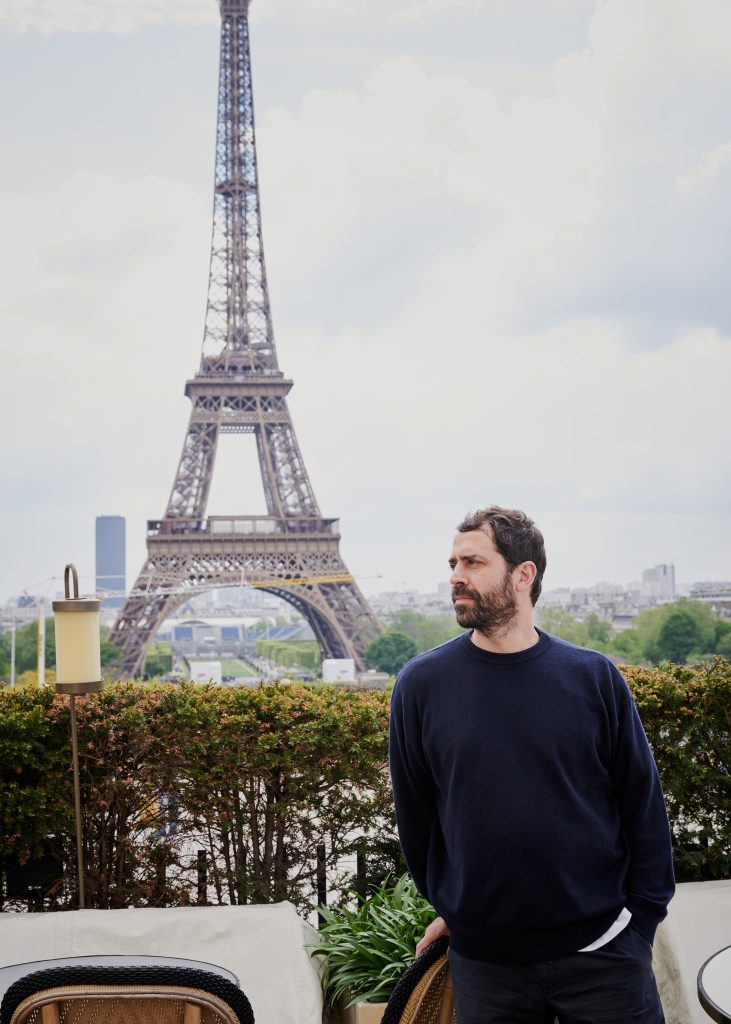 Chef Ignacio Mattos on the patio of Girafe in front of the Eiffel Tower, image courtesy of Caspar Miskin