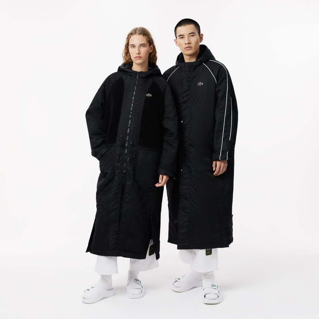 A man and a woman wearing the Lacost and CLOT reversible parka