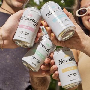 four hands holding four cans of Nowadays's canned cannabis cocktails