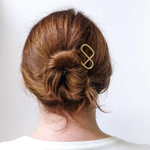 A modernist brass hair pin in a woman's hair