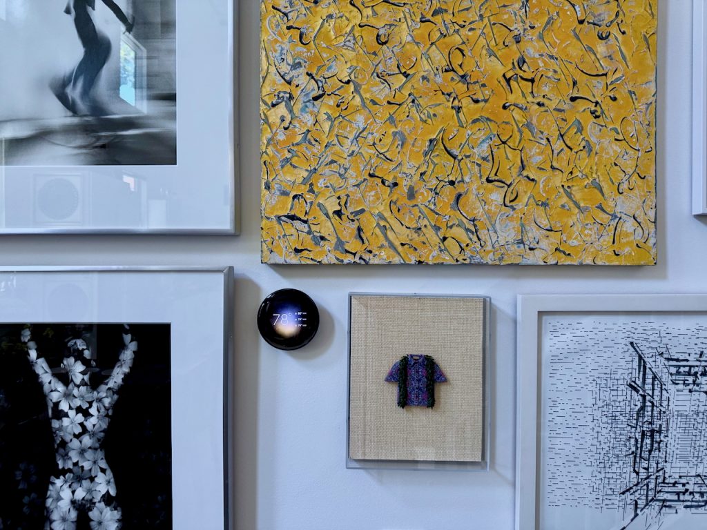 Nest thermostat on a wall surrounded by art