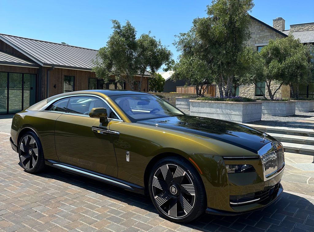 Rolls Royce Spectre in olive green parked on cobblestones on a sunny day