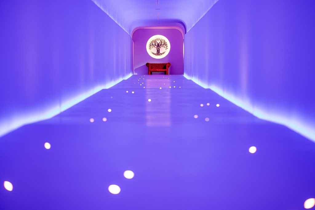 A beautifully lit tunnel—showing purple hues—joins two areas of the property